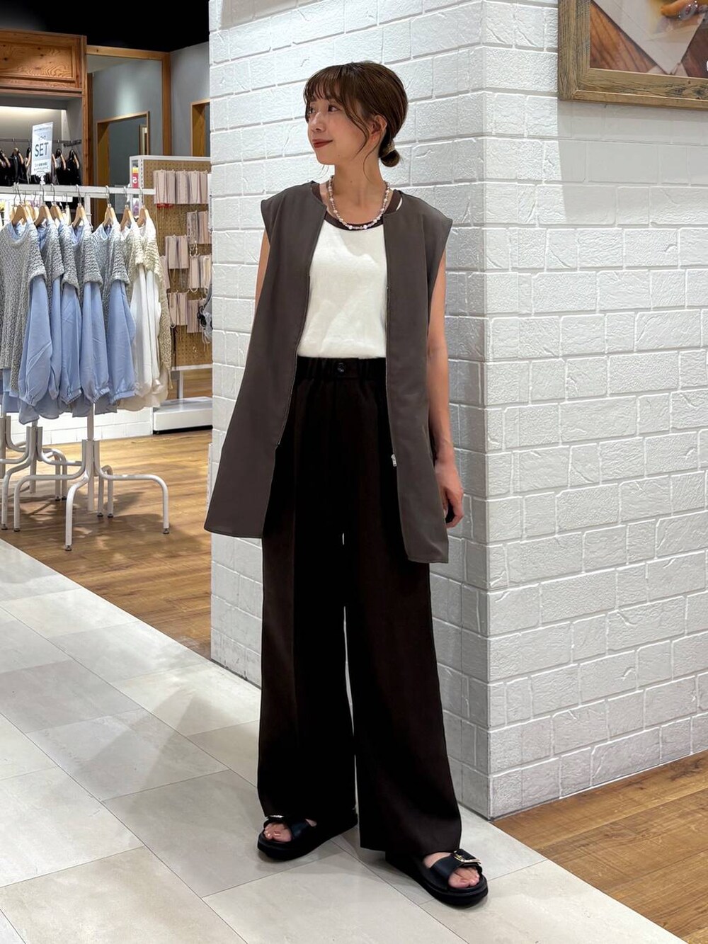 ベージュ系のタンクトップ、ブラウン系のベスト、ブラウン系のその他パンツを着用したレディースの夏コーディネートの4枚目の写真