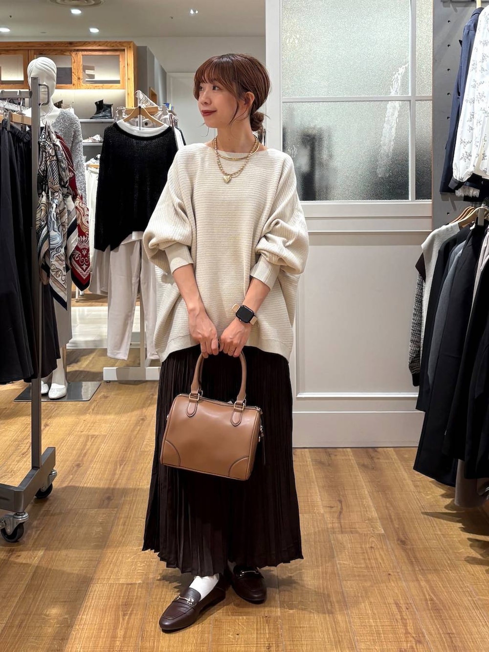 ブラウン系のローファー、グレー系のニット/セーター、ベージュ系のボストンバッグを着用したレディースの秋コーディネートの7枚目の写真