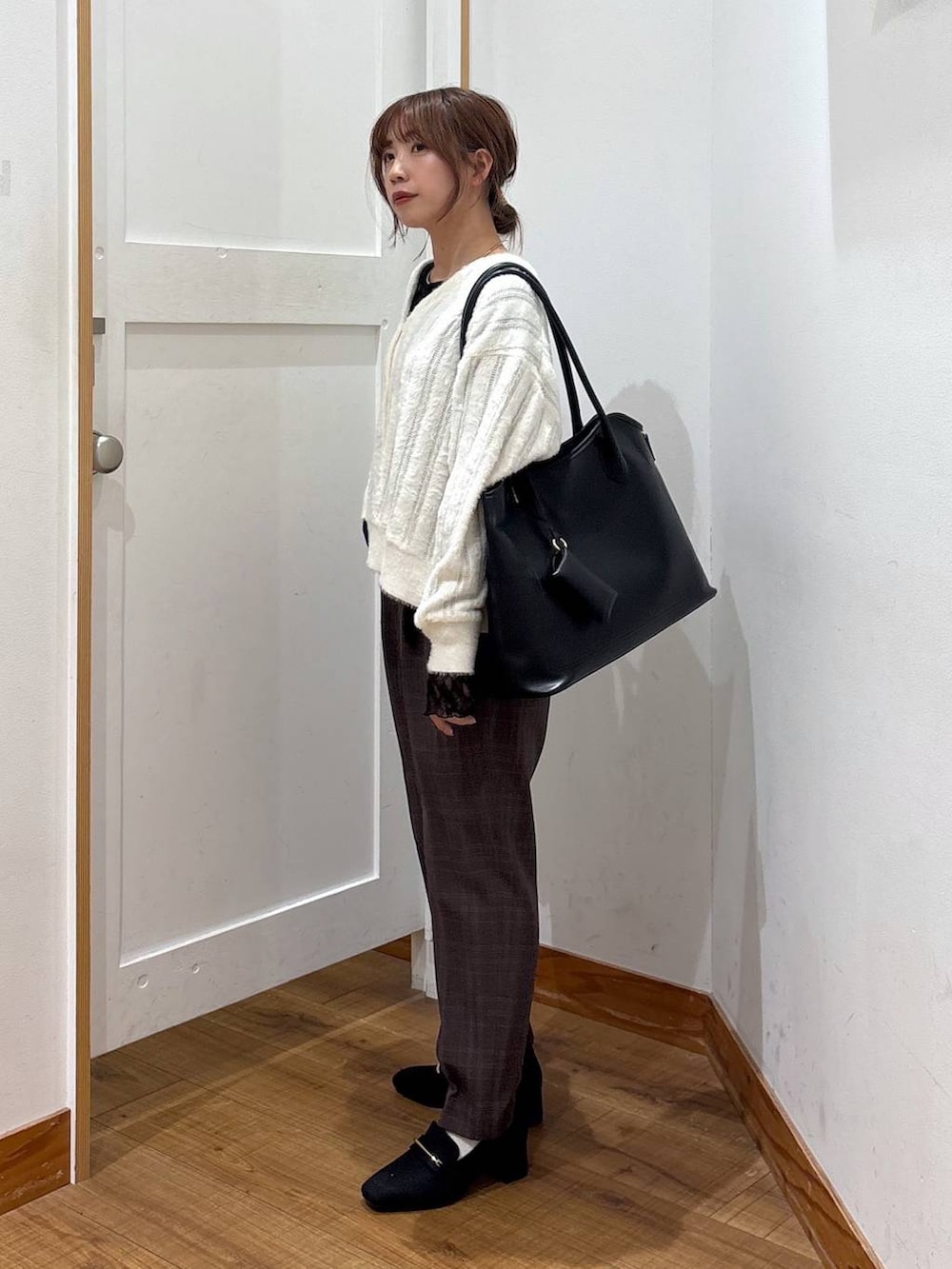 ブラック系のローファー、ブラック系のトートバッグ、ホワイト系のカーディガン/ボレロを着用したレディースの秋コーディネートの2枚目の写真