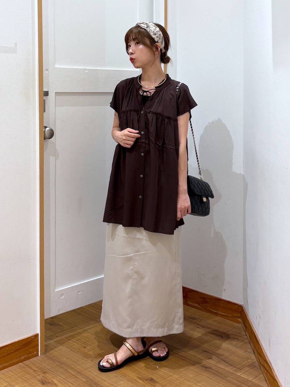 ブラック系のショルダーバッグ、ブラック系のタンクトップ、グレー系のスカートを着用したレディースの夏コーディネートの4枚目の写真