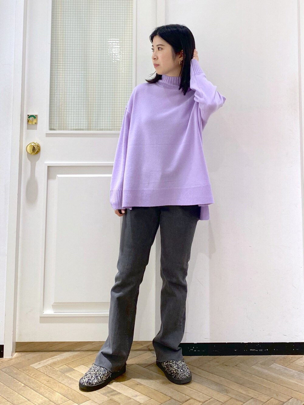 パープル系のニット/セーター、ブラック系のデニムパンツ、ブラック系のスリッポンを着用したレディースの冬コーディネートの4枚目の写真