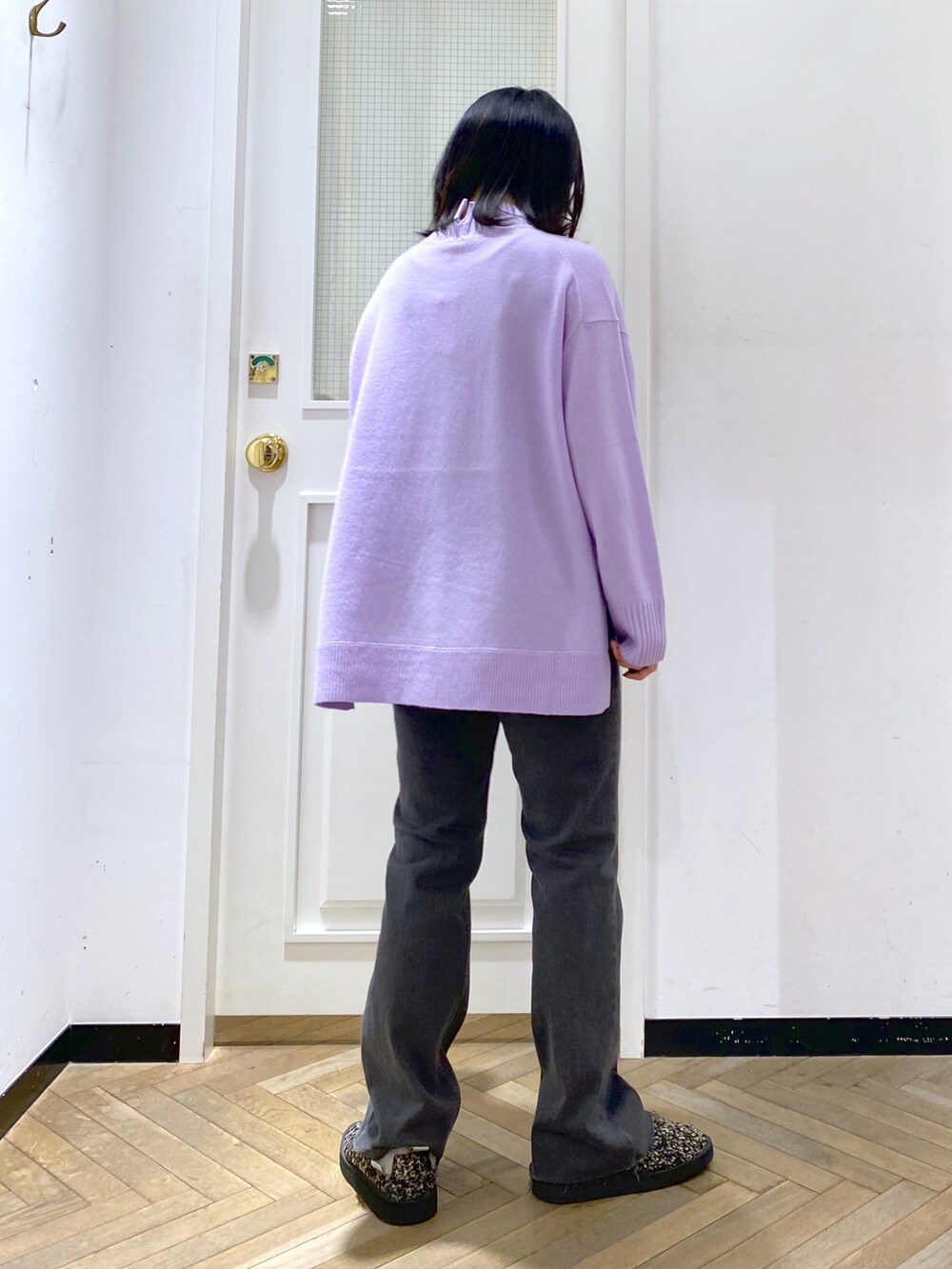 パープル系のニット/セーター、ブラック系のデニムパンツ、ブラック系のスリッポンを着用したレディースの冬コーディネートの3枚目の写真
