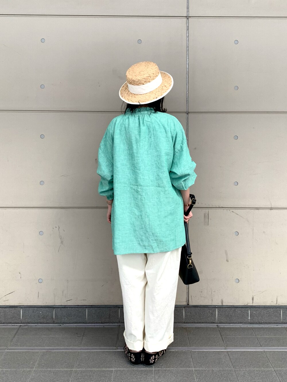 ブラック系のハンドバッグ、ブラック系のドレスシューズ、ホワイト系のその他パンツを着用したレディースの春コーディネートの3枚目の写真