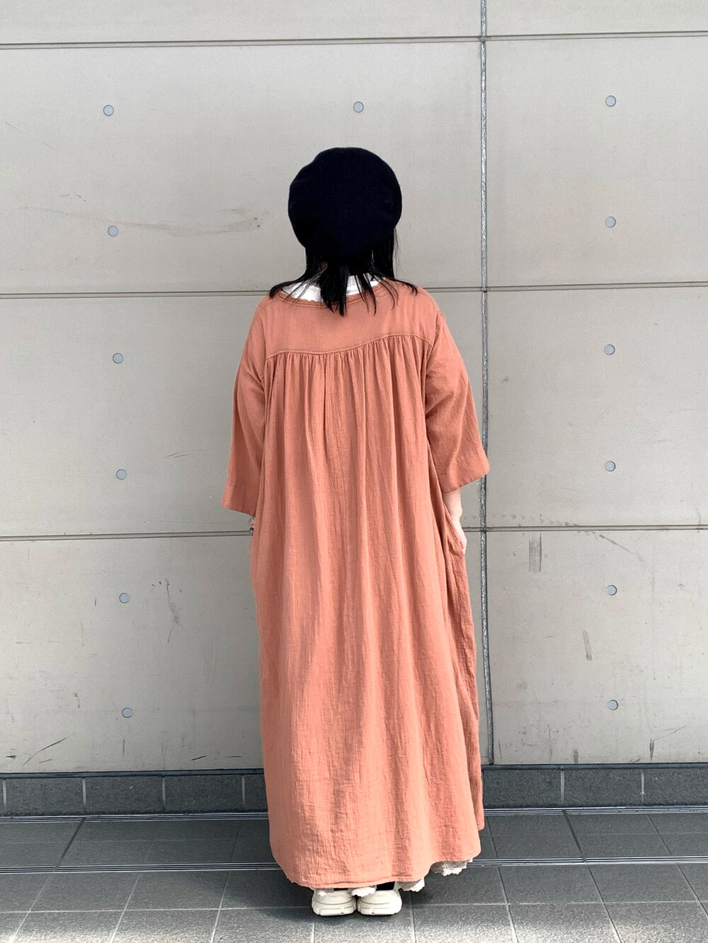 ベージュ系のTシャツ/カットソー、オレンジ系のワンピース/ドレス、ベージュ系のスカートを着用したレディースの夏コーディネートの3枚目の写真