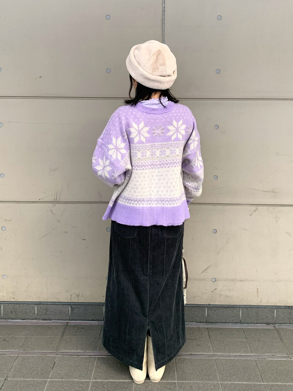 パープル系のTシャツ/カットソー、パープル系のニット/セーター、グレー系のスカートを着用したレディースの冬コーディネートの2枚目の写真