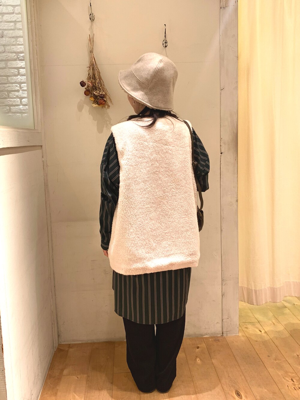 ホワイト系のキャミソール、ブラウン系のベスト、ピンク系のその他パンツを着用したレディースの秋コーディネートの2枚目の写真