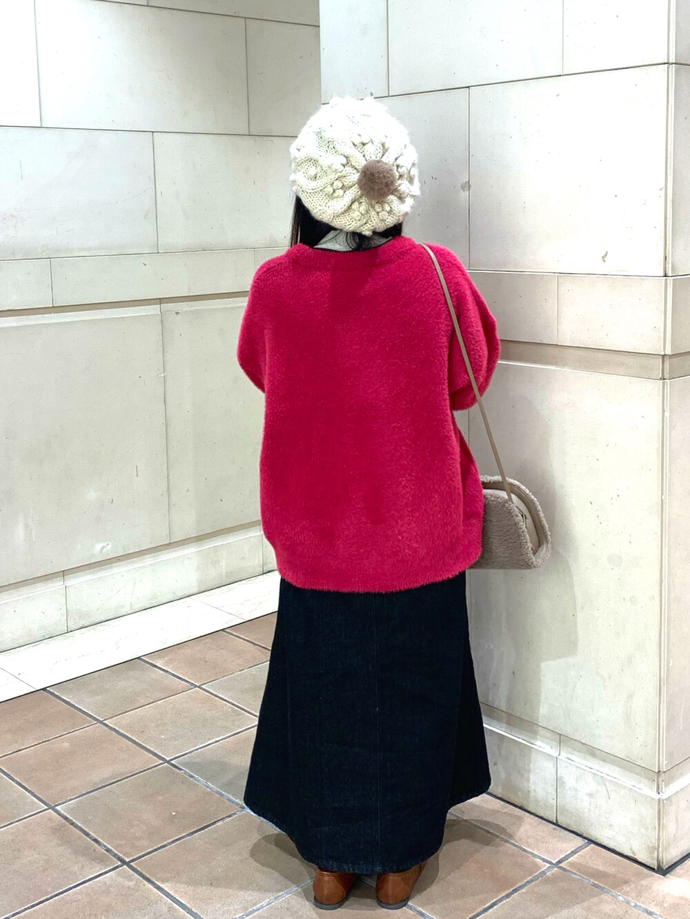 ピンク系のカーディガン/ボレロ、ブラック系のニット/セーター、ブラウン系のハンドバッグを着用したレディースの冬コーディネートの2枚目の写真