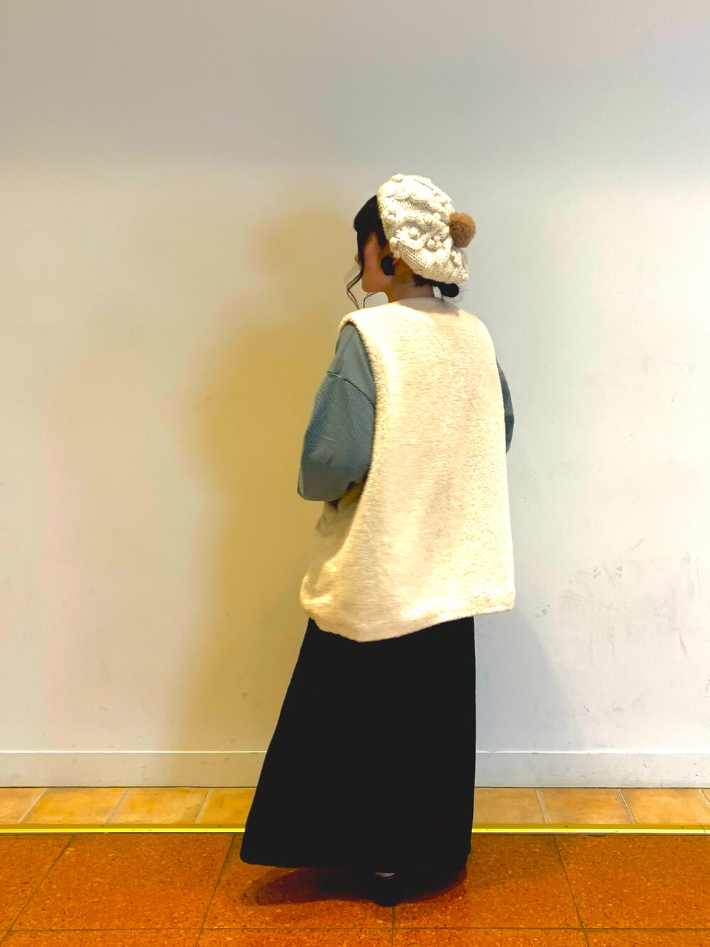 ブラウン系のベスト、ブラック系のデニムスカート、ブラック系のドレスシューズを着用したレディースの冬コーディネートの3枚目の写真