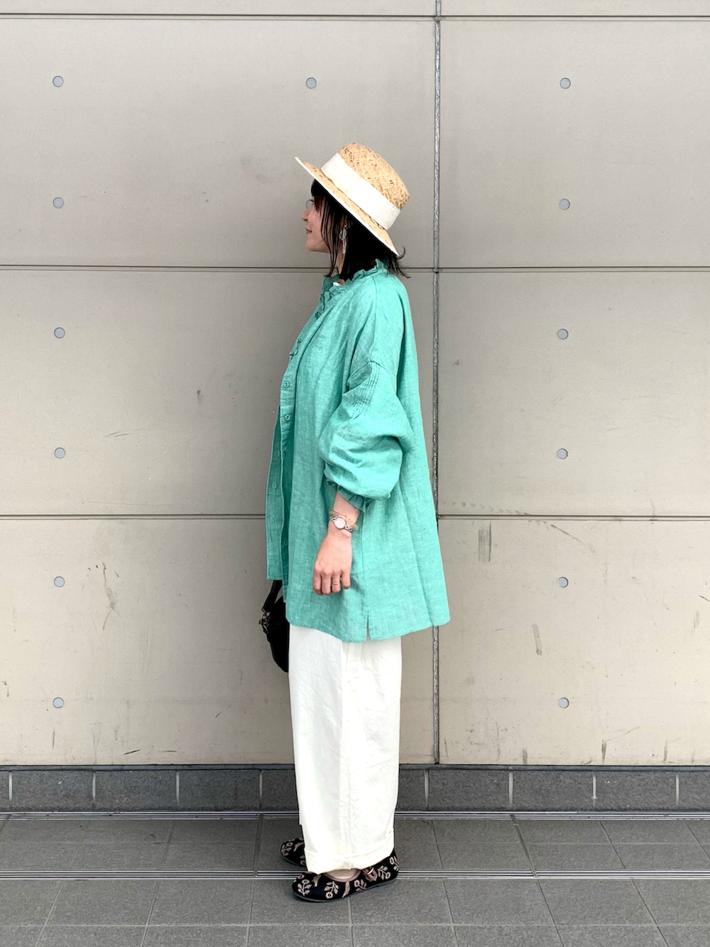 ブラック系のハンドバッグ、ブラック系のドレスシューズ、ホワイト系のその他パンツを着用したレディースの春コーディネートの2枚目の写真