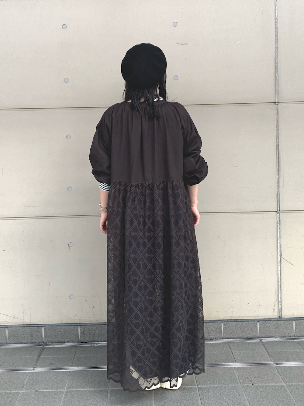ブラック系のワンピース、ブラック系のTシャツ/カットソー、ブルー系のデニムパンツを着用したレディースの秋コーディネートの2枚目の写真