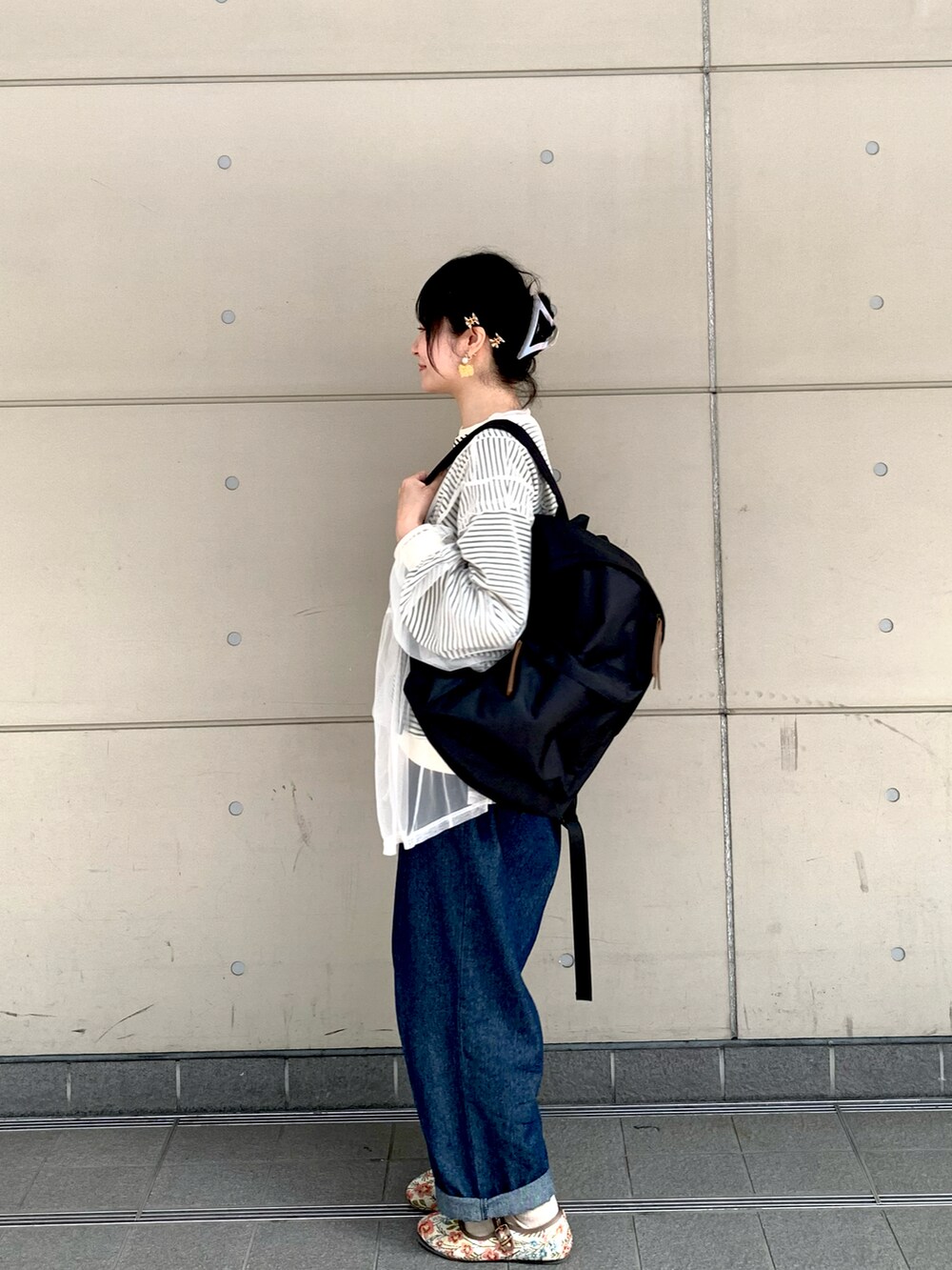 ブラック系のTシャツ/カットソー、ホワイト系のTシャツ/カットソー、ブラック系のハンドバッグを着用したレディースの春コーディネートの2枚目の写真