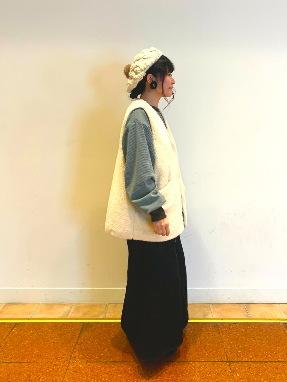 ブラウン系のベスト、ブラック系のデニムスカート、ブラック系のドレスシューズを着用したレディースの冬コーディネートの2枚目の写真