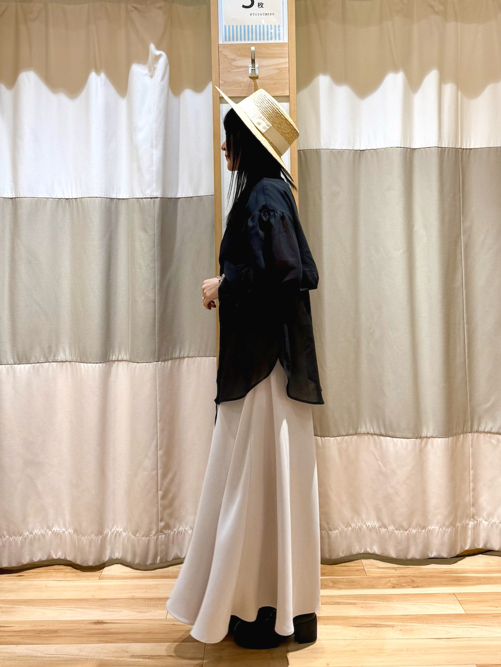 ブラック系のシャツ/ブラウス、ベージュ系のスカートを着用したレディースの春コーディネートの2枚目の写真