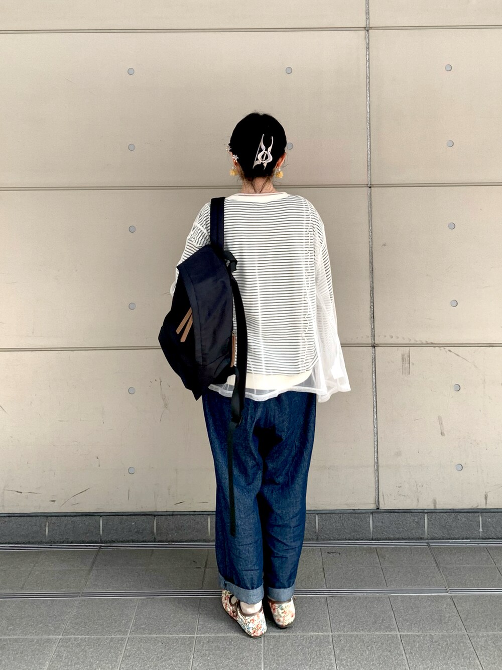 ブラック系のTシャツ/カットソー、ホワイト系のTシャツ/カットソー、ブラック系のハンドバッグを着用したレディースの春コーディネートの3枚目の写真