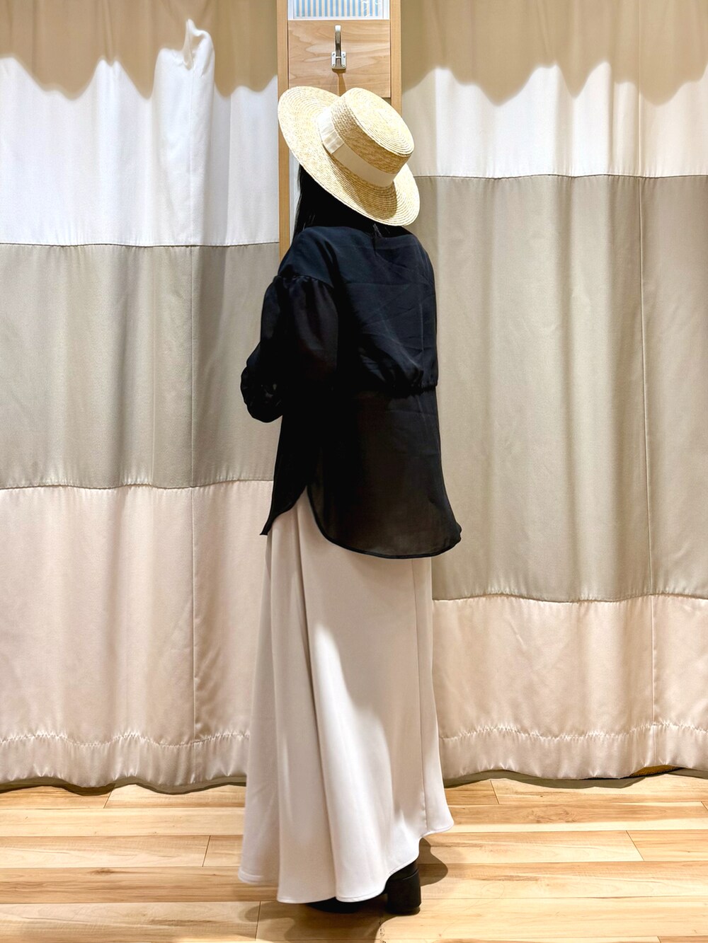 ブラック系のシャツ/ブラウス、ベージュ系のスカートを着用したレディースの春コーディネートの3枚目の写真