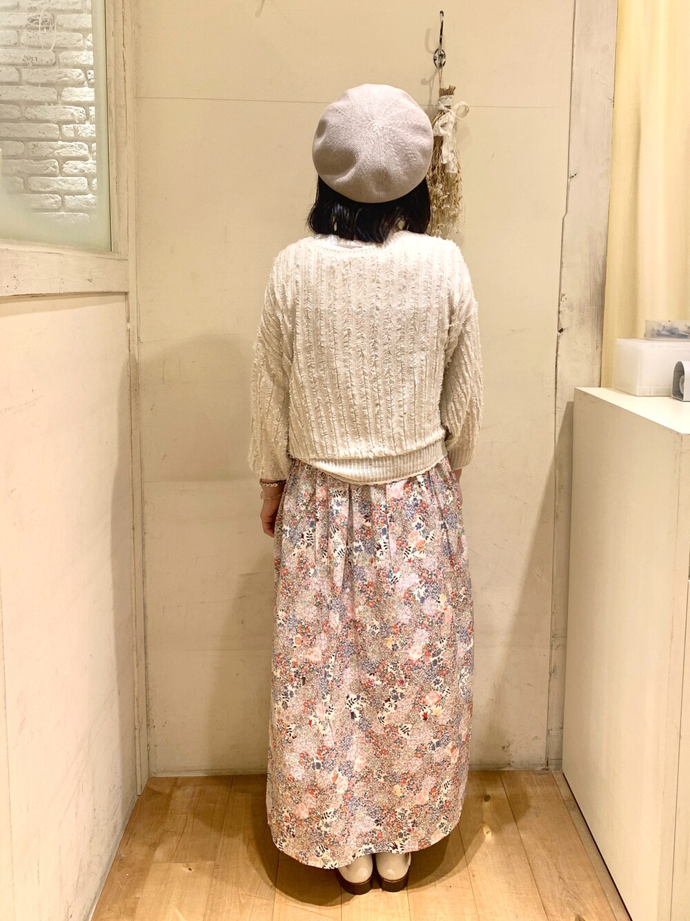 ベージュ系のカーディガン/ボレロ、ピンク系のワンピース/ドレス、ホワイト系のサンダルを着用したレディースの春コーディネートの3枚目の写真