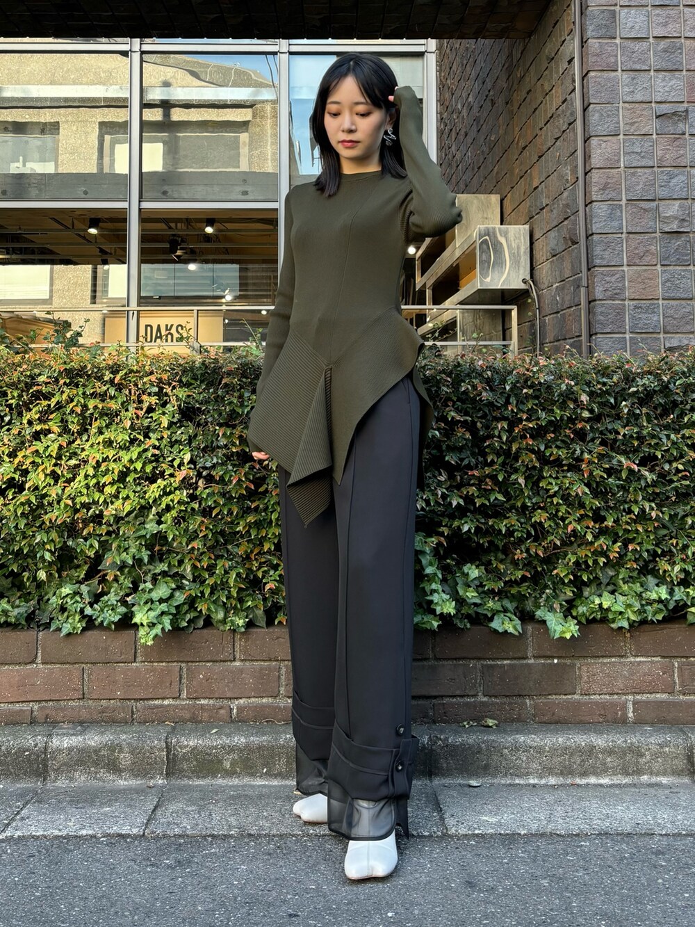 グリーン系のニット/セーター、ブラック系のその他パンツ、ベージュ系のブーツを着用したレディースの冬コーディネートの2枚目の写真