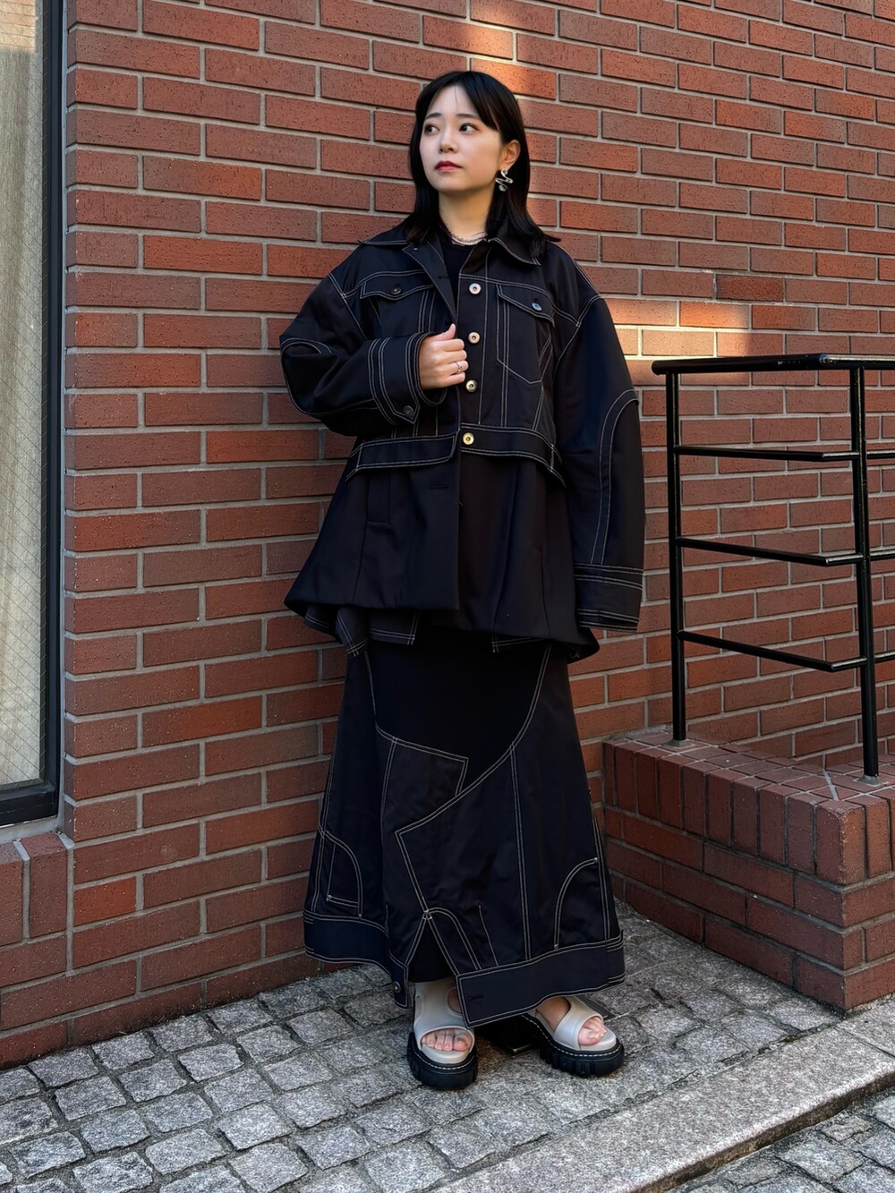 ブラック系のTシャツ/カットソー、ブラック系のスカートを着用したレディースの冬コーディネートの2枚目の写真