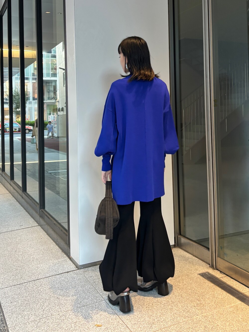 ブラック系のハンドバッグ、ブルー系のニット/セーター、ブラック系のその他パンツを着用したレディースの秋コーディネートの3枚目の写真