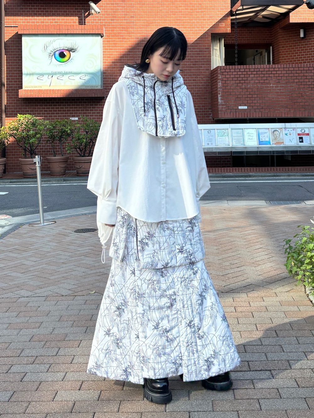 ホワイト系のシャツ/ブラウス、ホワイト系のスカート、ホワイト系のネックウォーマー/スヌードを着用したレディースの秋コーディネートの3枚目の写真