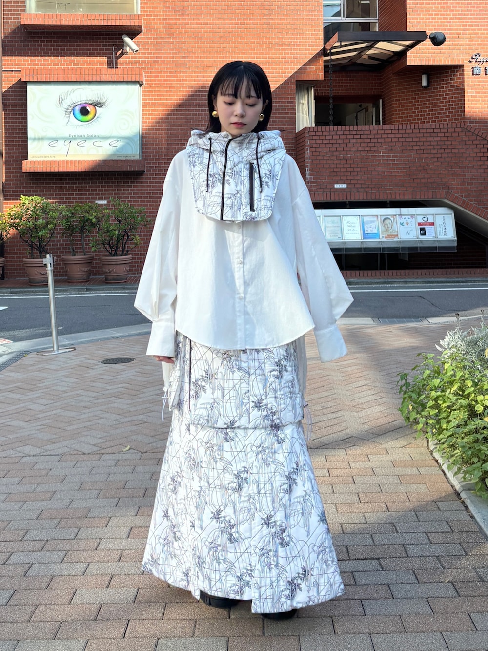 ホワイト系のシャツ/ブラウス、ホワイト系のスカート、ホワイト系のネックウォーマー/スヌードを着用したレディースの秋コーディネートの2枚目の写真