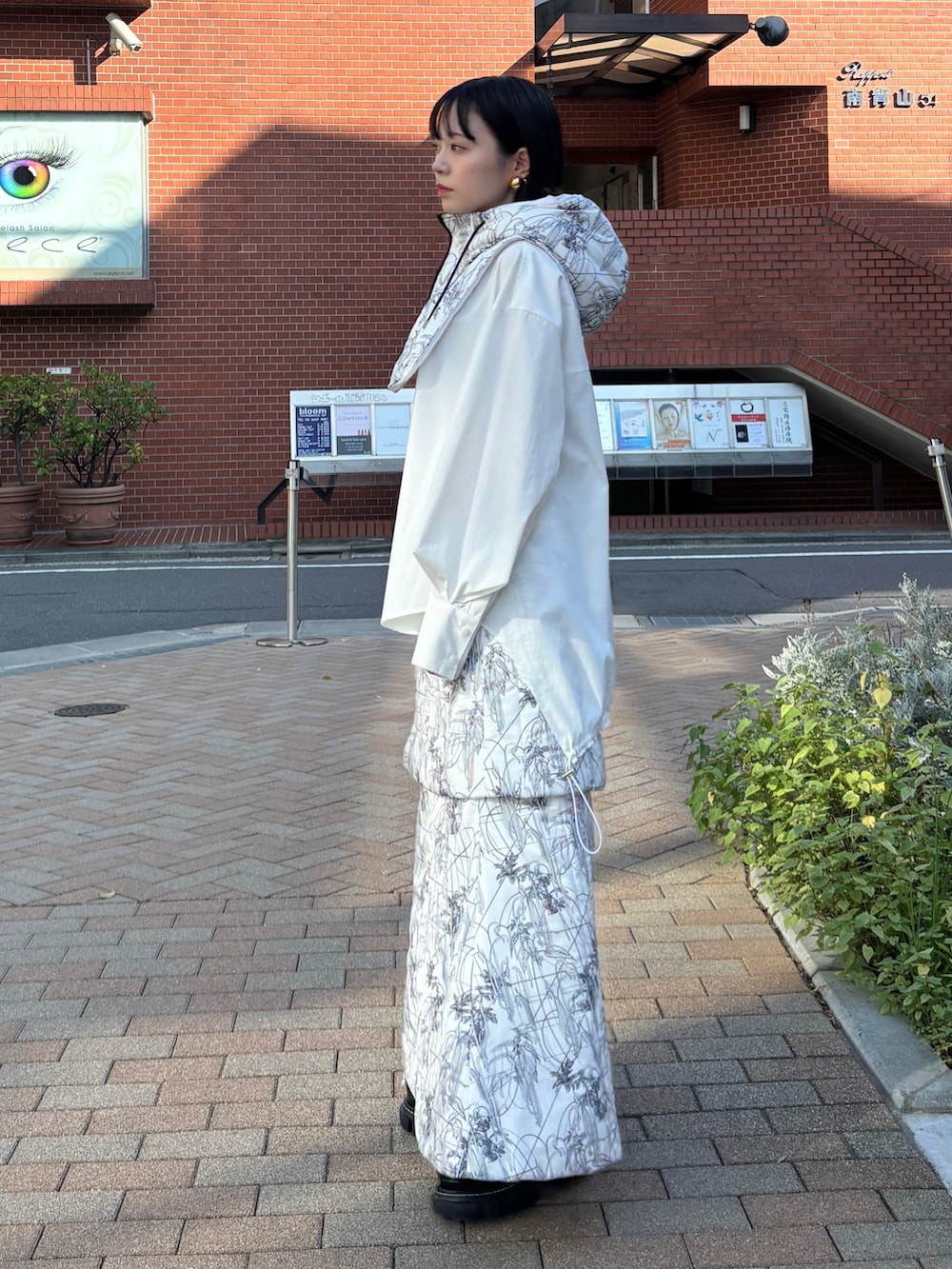 ホワイト系のシャツ/ブラウス、ホワイト系のスカート、ホワイト系のネックウォーマー/スヌードを着用したレディースの秋コーディネートの4枚目の写真