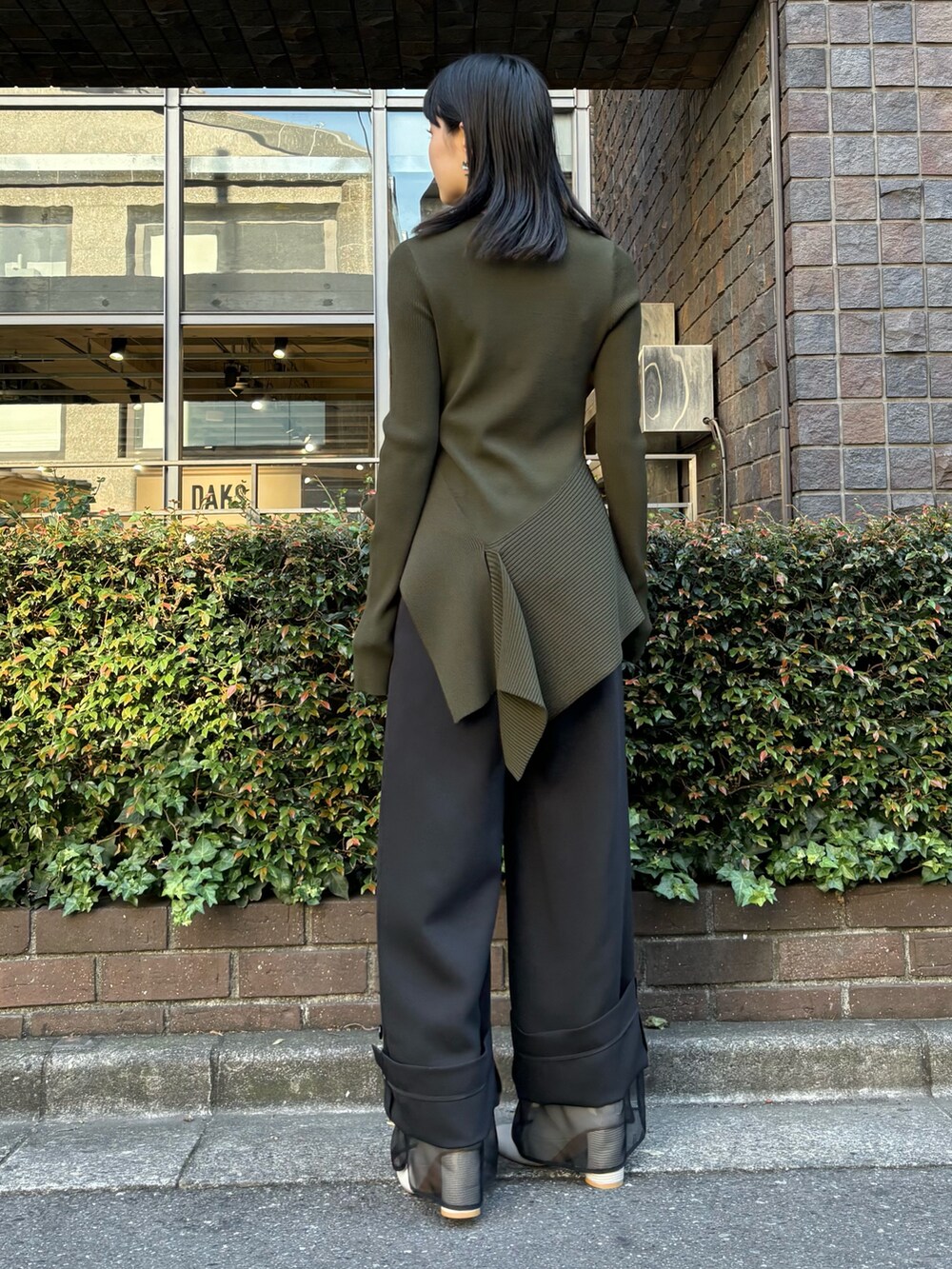 グリーン系のニット/セーター、ブラック系のその他パンツ、ベージュ系のブーツを着用したレディースの冬コーディネートの3枚目の写真