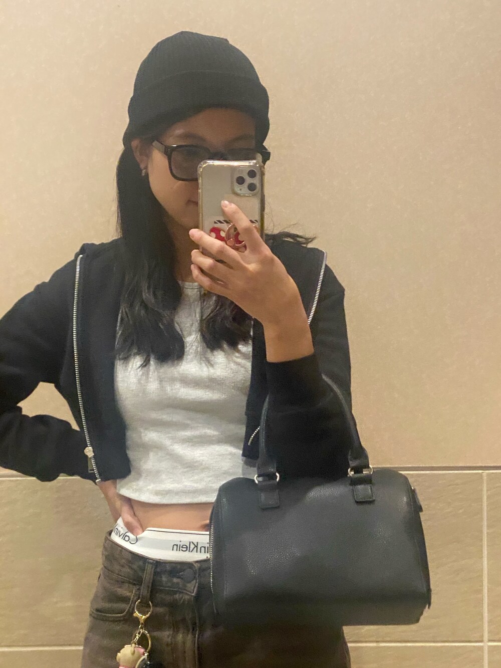 ブラック系のブーツ、ブラック系のデニムパンツ、ブラック系のボストンバッグを着用したレディースの冬コーディネートの2枚目の写真