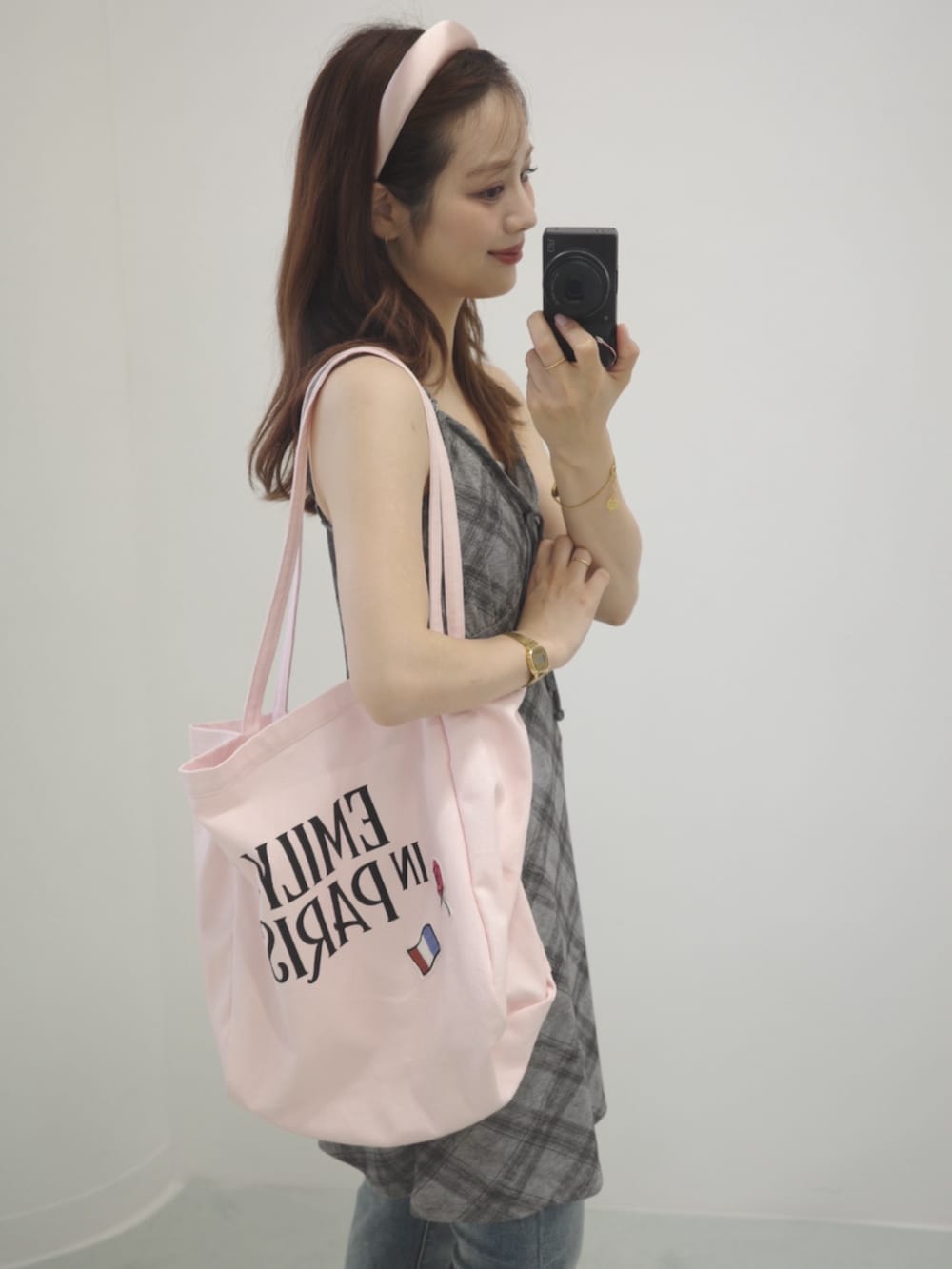グレー系のワンピース、ブルー系のデニムパンツ、シルバー系のサンダルを着用したレディースの夏コーディネートの2枚目の写真
