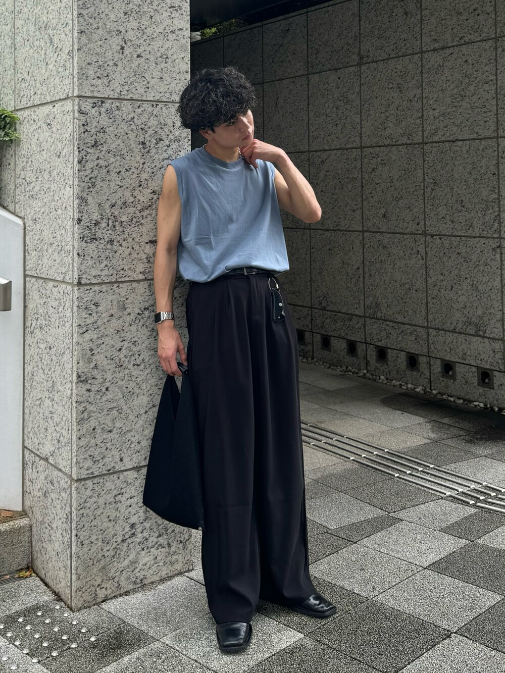 ブラック系のトップス、ブルー系のデニムパンツ、ホワイト系のスニーカーを着用したメンズの夏コーディネートの3枚目の写真