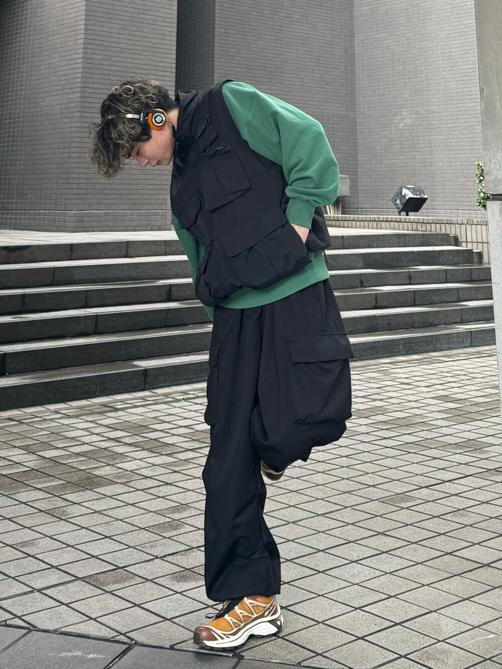 グリーン系のスウェット、オレンジ系のスニーカー、ブラック系のその他パンツを着用したメンズの春コーディネートの2枚目の写真