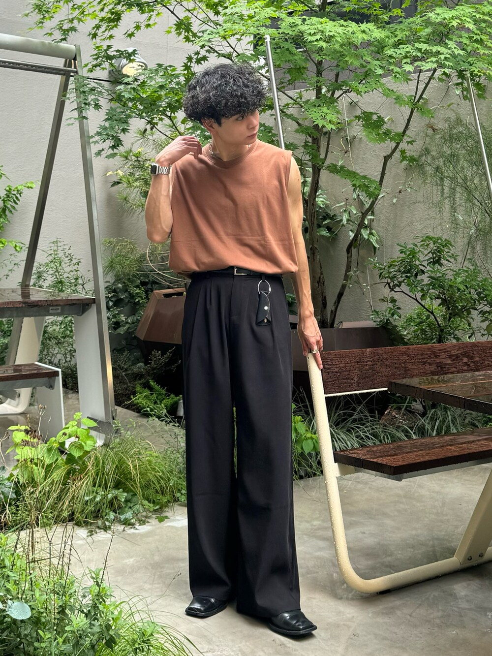 ブラック系のトップス、ブルー系のデニムパンツ、ホワイト系のスニーカーを着用したメンズの夏コーディネートの4枚目の写真