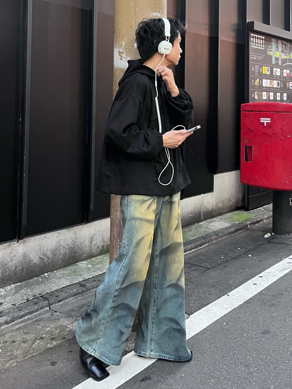 ブラック系のパーカー、ブルー系のデニムパンツを着用したメンズの秋コーディネートの2枚目の写真