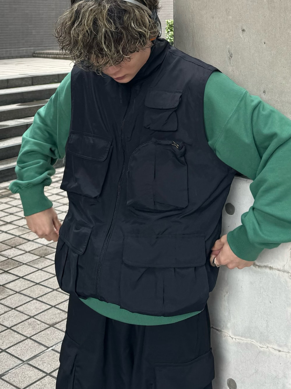 グリーン系のスウェット、オレンジ系のスニーカー、ブラック系のその他パンツを着用したメンズの春コーディネートの3枚目の写真