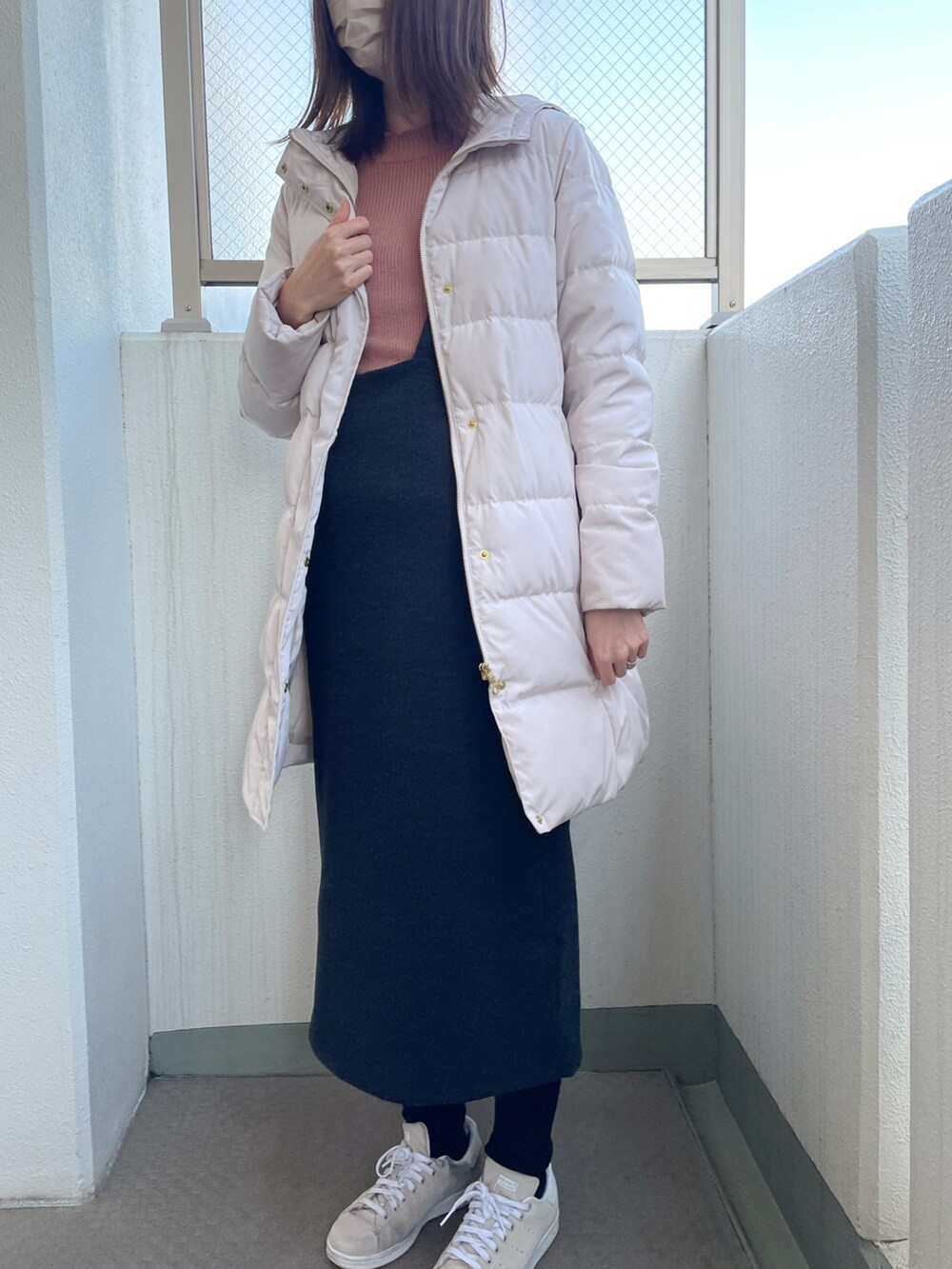 イエロー系のニット/セーター、グレー系のワンピース、ブラウン系のスニーカーを着用したレディースの冬コーディネートの2枚目の写真