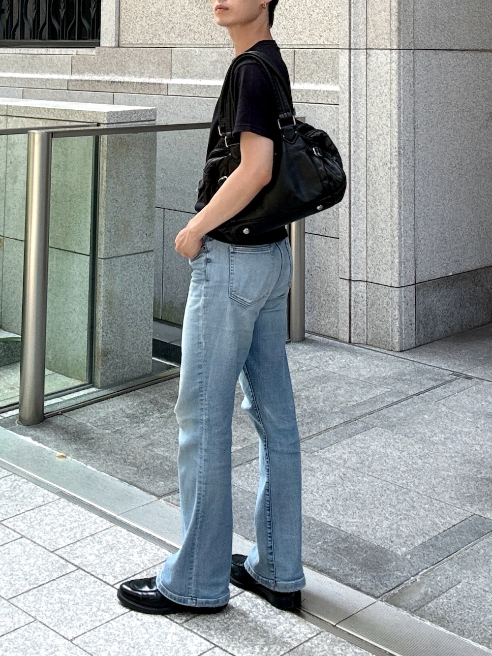 ブラック系のローファー、ブルー系のデニムパンツ、ブラック系のTシャツ/カットソーを着用したメンズの夏コーディネートの3枚目の写真