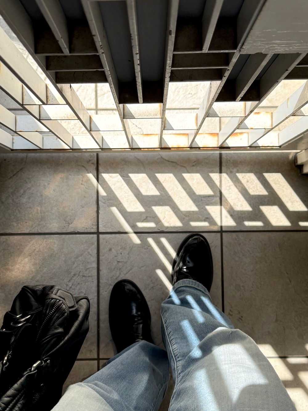 ブラック系のローファー、ブルー系のデニムパンツ、ブラック系のTシャツ/カットソーを着用したメンズの夏コーディネートの2枚目の写真