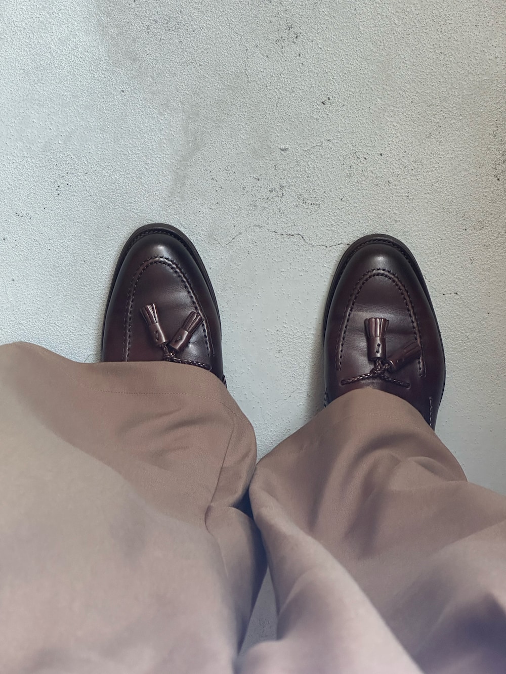 ブラウン系のスラックス、ブラウン系のローファーを着用したメンズの夏コーディネートの2枚目の写真