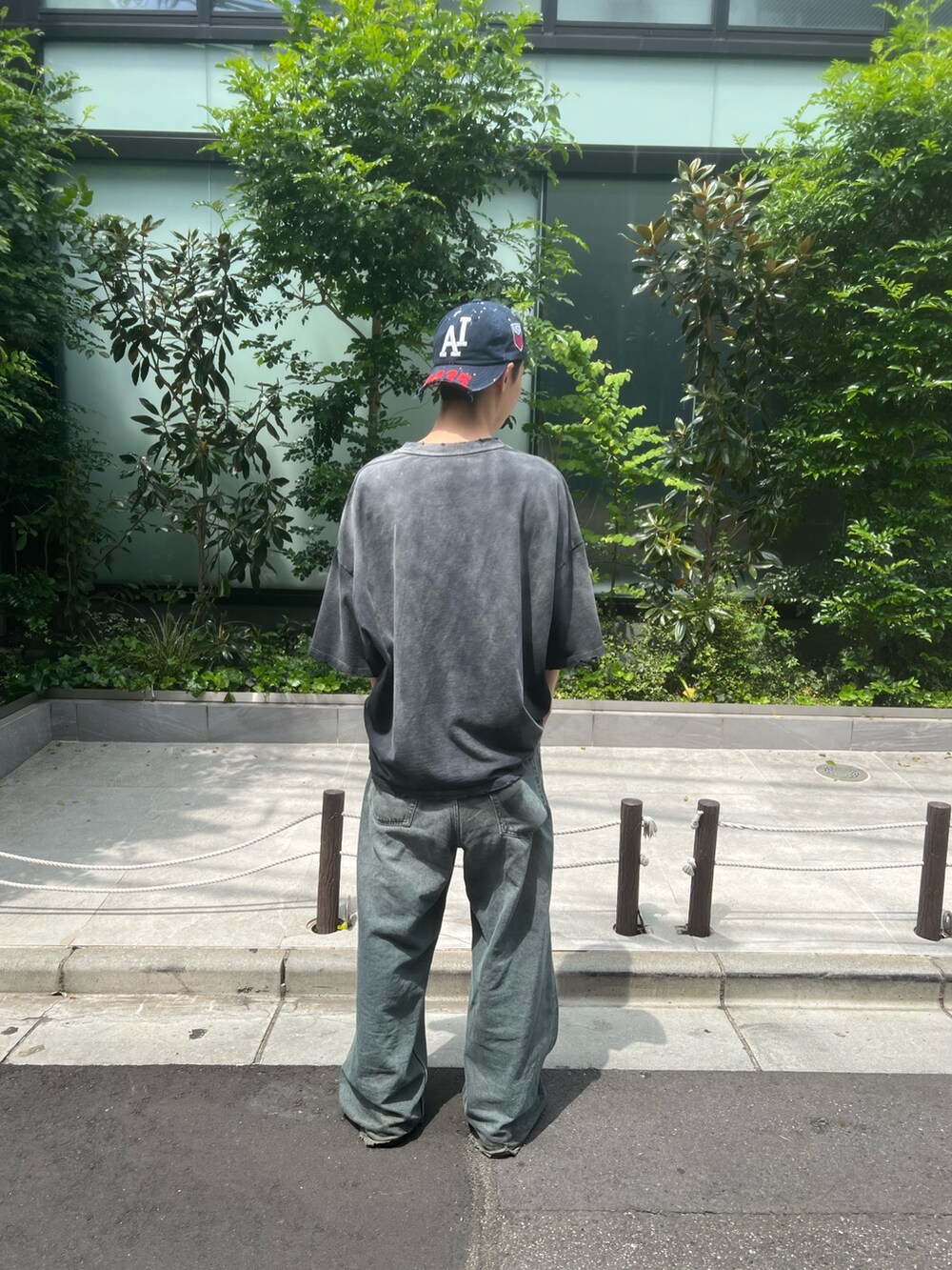 ブラック系のTシャツ/カットソーを着用したメンズの春コーディネートの2枚目の写真