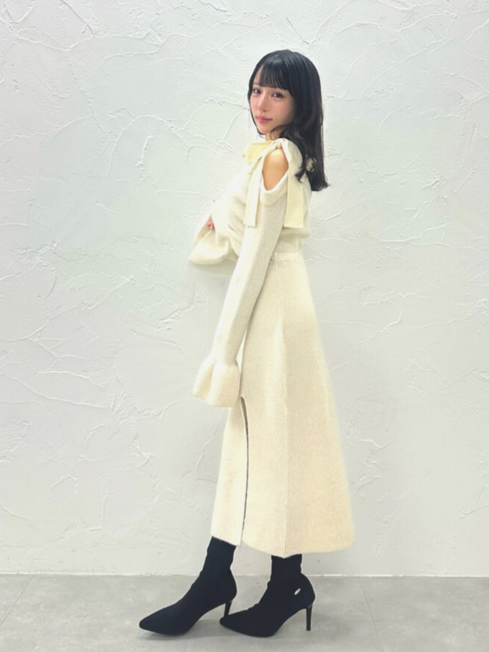 ブラック系のブーツ、ホワイト系のワンピースを着用したレディースの冬コーディネートの6枚目の写真