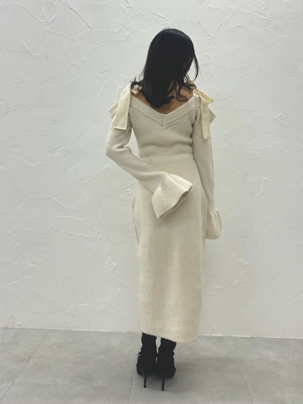 ブラック系のブーツ、ホワイト系のワンピースを着用したレディースの冬コーディネートの7枚目の写真