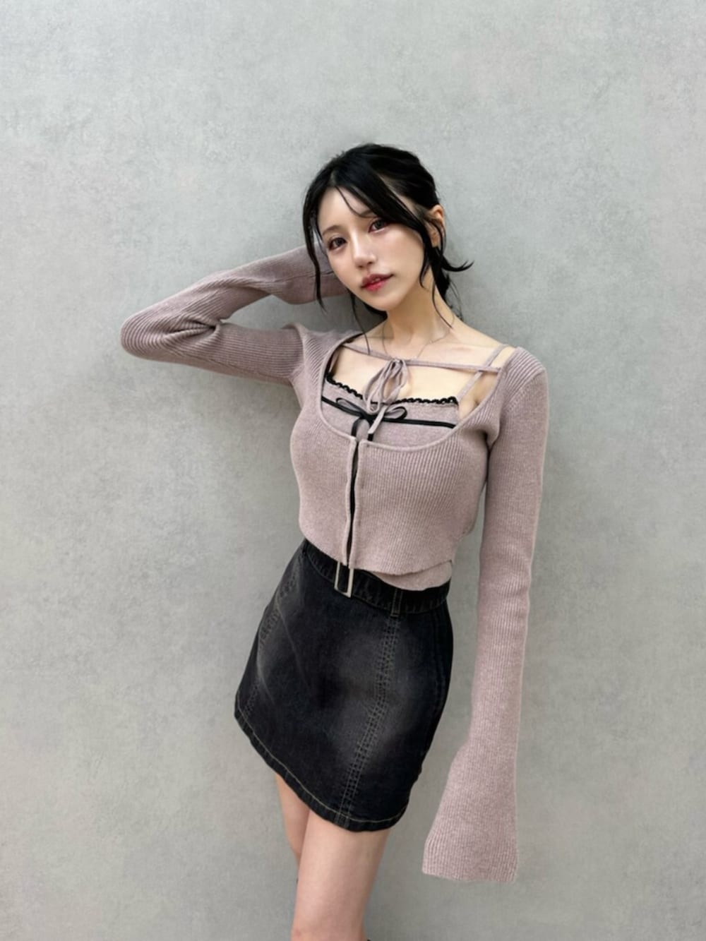 ブラック系のデニムスカート、ブラック系のブーツ、ベージュ系のニット/セーターを着用したレディースの秋コーディネートの8枚目の写真