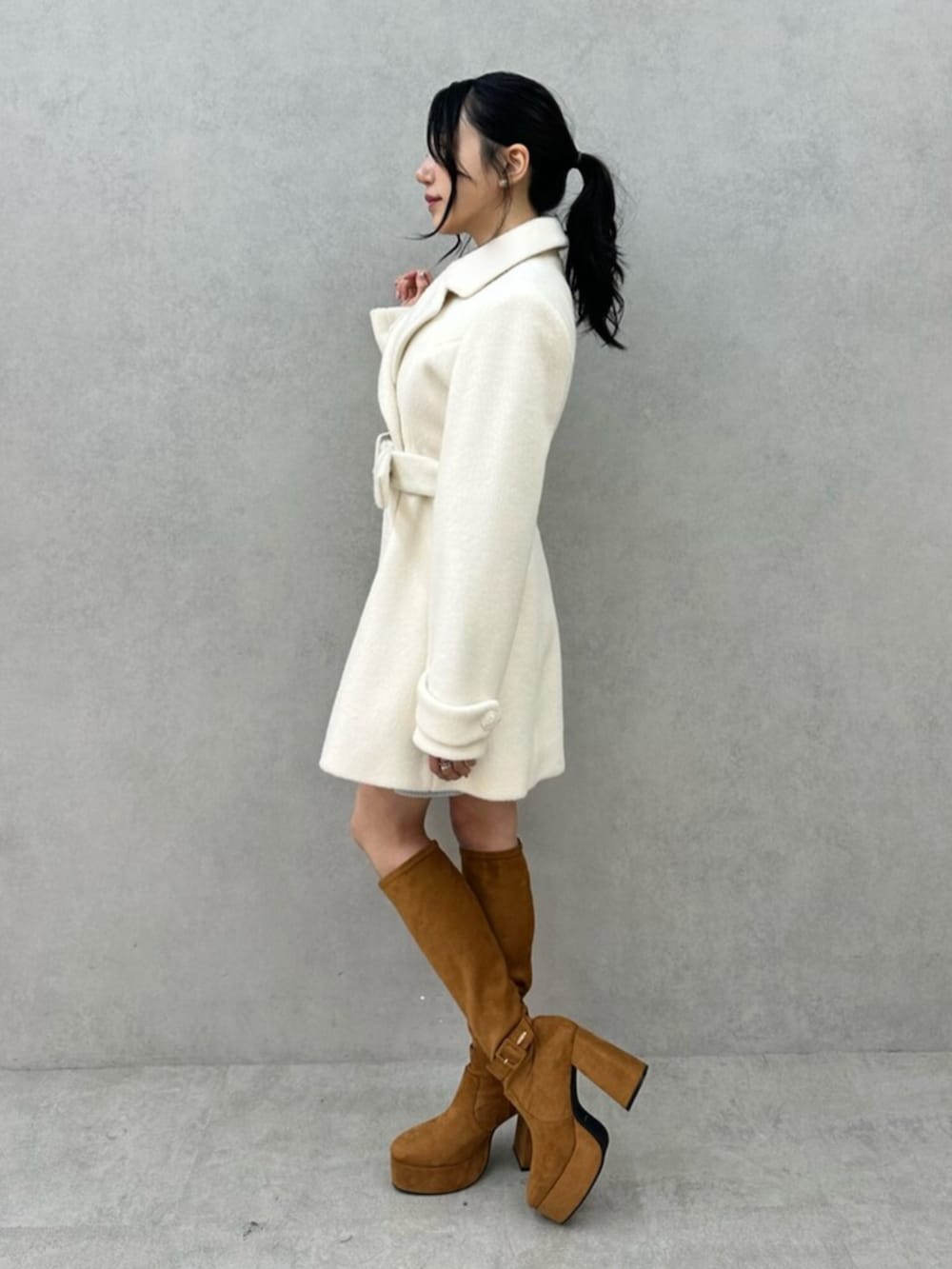 ホワイト系のその他アウター、ブラウン系のブーツを着用したレディースの秋コーディネートの6枚目の写真