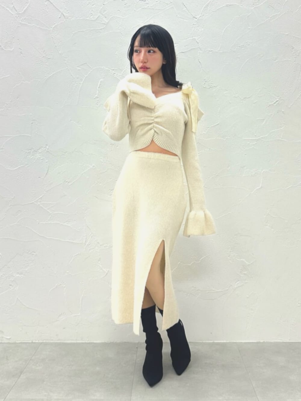 ブラック系のブーツ、ホワイト系のワンピースを着用したレディースの冬コーディネートの3枚目の写真