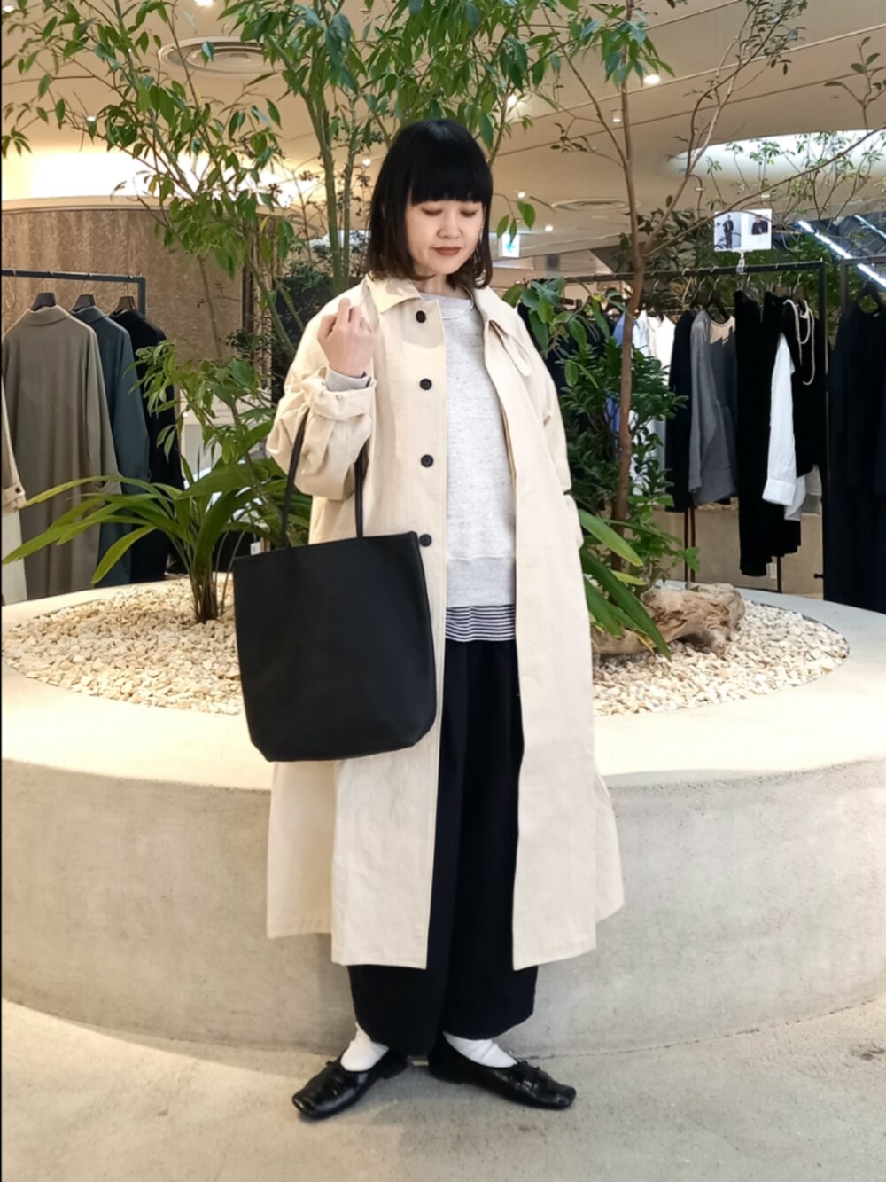 ベージュ系のスウェット、ホワイト系のステンカラーコート、ブラック系のTシャツ/カットソーを着用したレディースの冬コーディネートの6枚目の写真