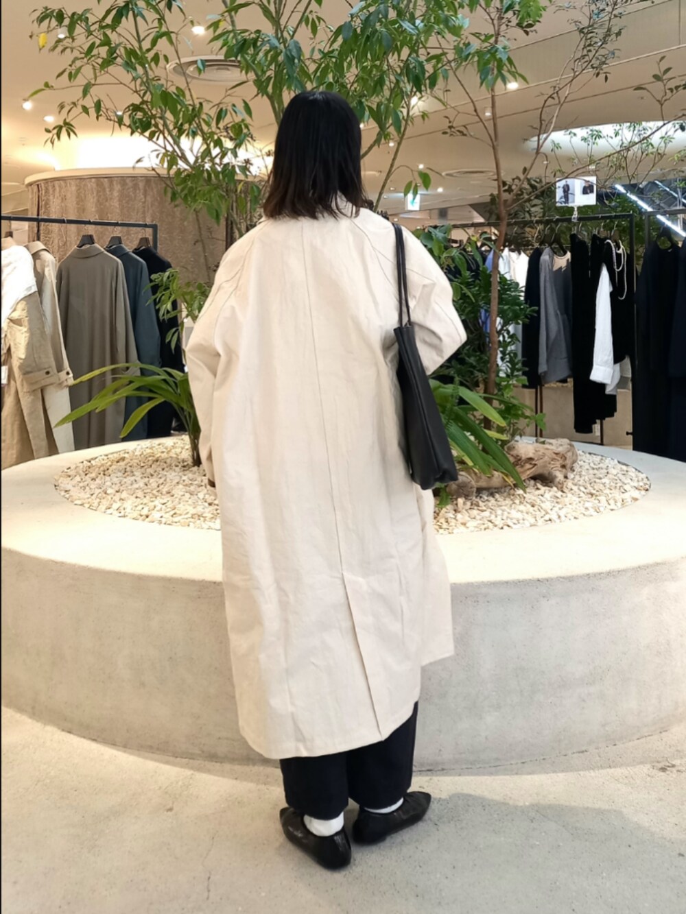 ベージュ系のスウェット、ホワイト系のステンカラーコート、ブラック系のTシャツ/カットソーを着用したレディースの冬コーディネートの4枚目の写真