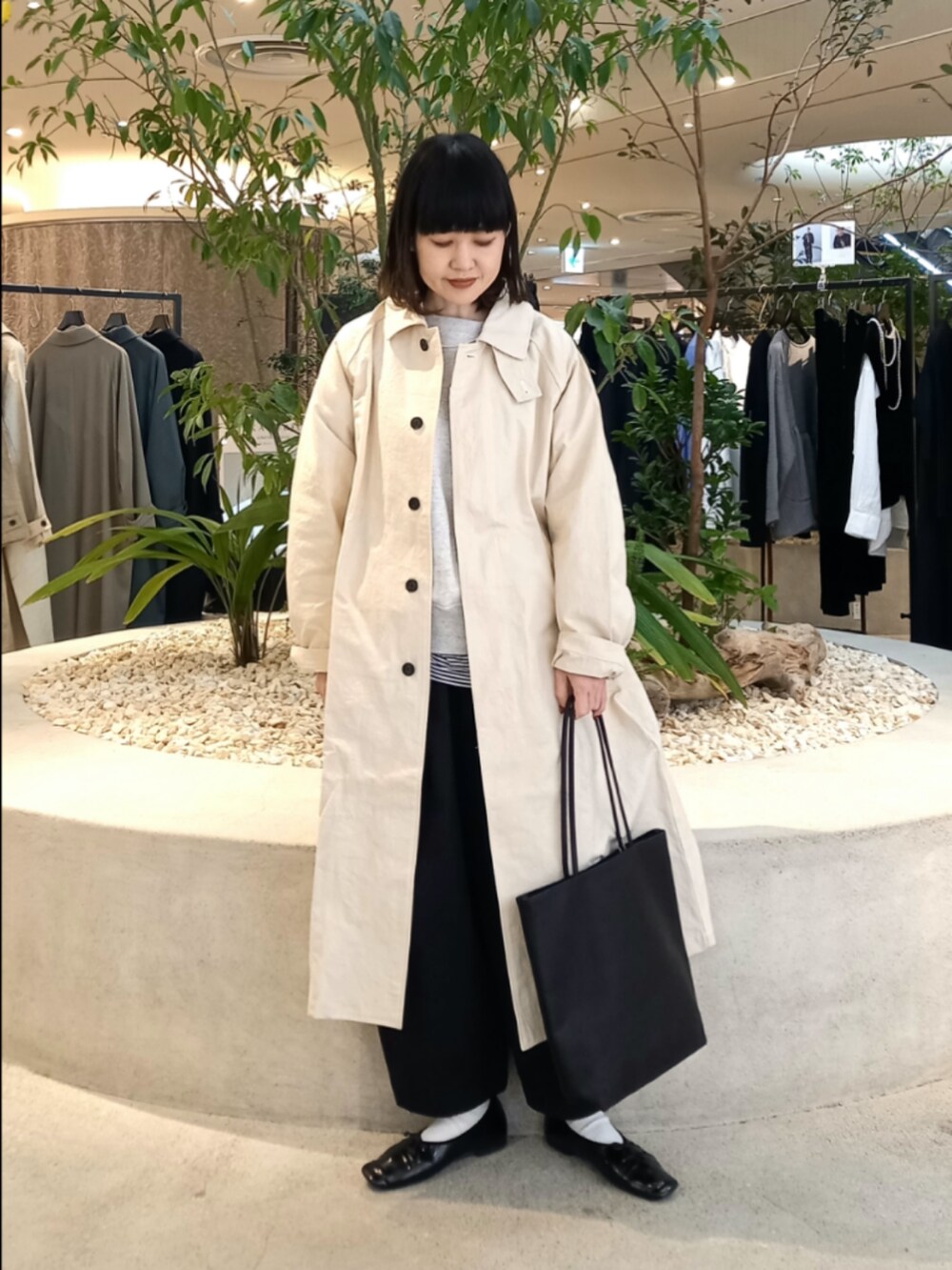 ベージュ系のスウェット、ホワイト系のステンカラーコート、ブラック系のTシャツ/カットソーを着用したレディースの冬コーディネートの5枚目の写真