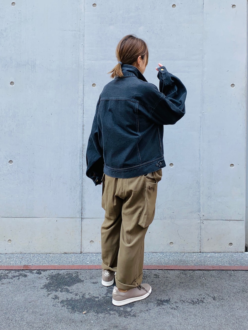 ブラック系のニット/セーター、グリーン系のサロペット/オーバーオール、ブラック系のデニムジャケットを着用したレディースの秋コーディネートの2枚目の写真