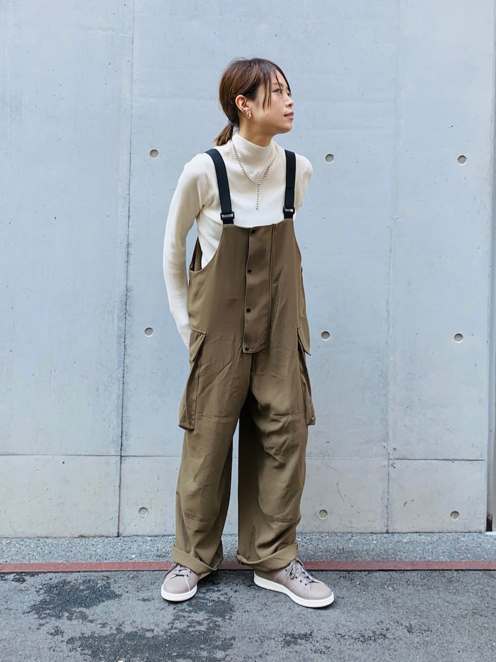 ブラック系のニット/セーター、グリーン系のサロペット/オーバーオール、ブラック系のデニムジャケットを着用したレディースの秋コーディネートの4枚目の写真