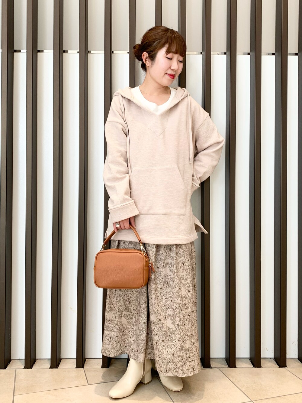 ホワイト系のブーツ、グリーン系のノーカラージャケット、ベージュ系のパーカーを着用したレディースの冬コーディネートの2枚目の写真